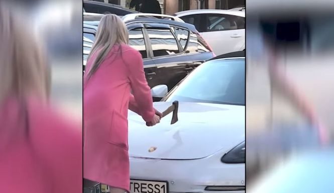Стало відомо, навіщо дівчина у рожевому пальто трощила сокирою Porsche у центрі Києва